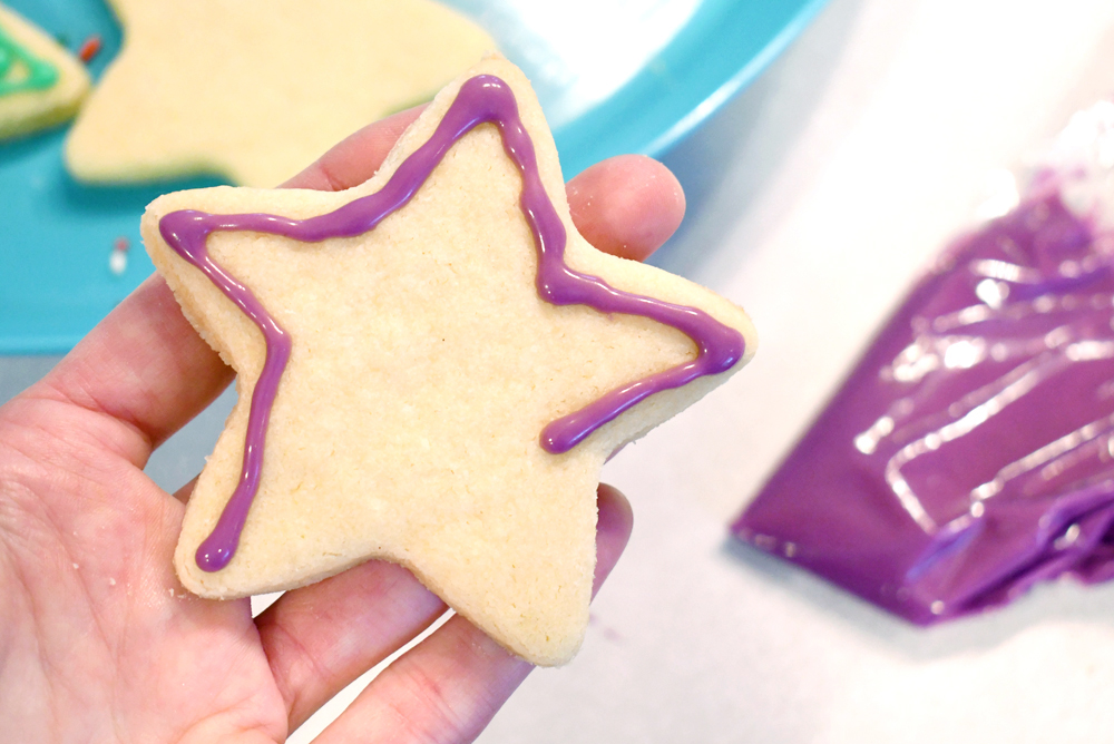Decorate sugar cookies using sandwich bags to pipe icing