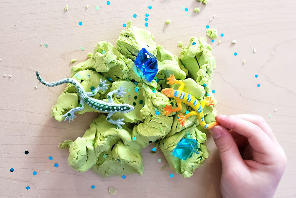 Homemade cloud dough kids activity with sensory glitter and tiny lizards