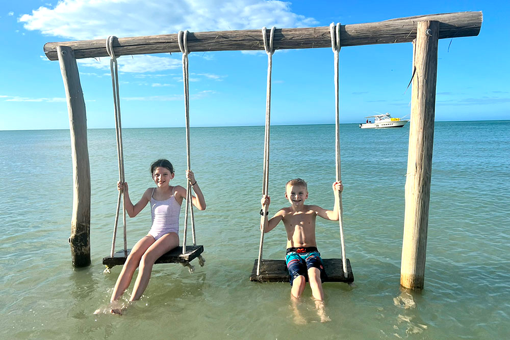 kids on beach swing at Pig Beach Progreso
